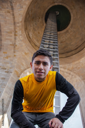 Photography From below a man looking at the camera in a huge architectonic structure