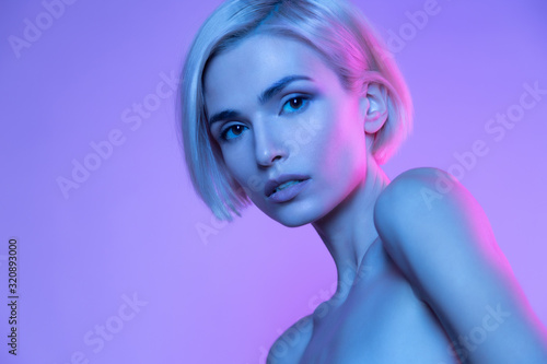 Фотография Beautiful european blond woman trendy glowing neon nude headshot art studio portrait