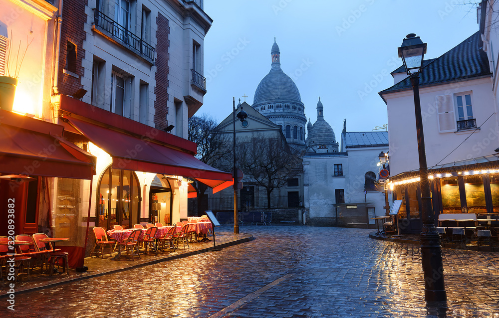 The Place du Tertre with tables of cafe and the Sacre-Coeur in the rainy morning, quarter Montmartre in Paris.