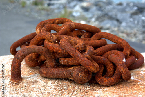Piles of Ocean buoys and rusty anchor chains on a dock