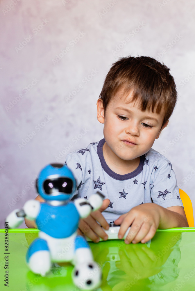 Little boy is playing with robot. Robot for children. Smart toy Little boy is playing with robot. Robot for children. Smart toy