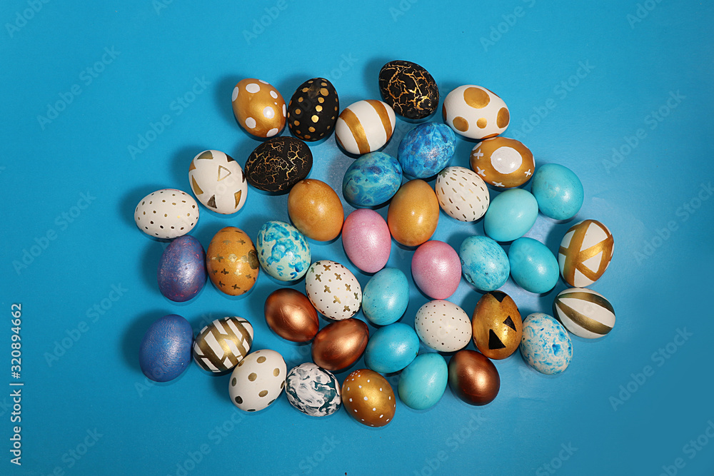 Decorated golden and blue easter eggs on a turquoise background. Minimal holiday concept. Happy easter background. Creative painting of eggs at home, the idea of simple drawings for coloring, Decorated golden and blue easter eggs on a turquoise background. Minimal holiday concept. Happy easter background. Creative painting of eggs at home, the idea of simple drawings for coloring,