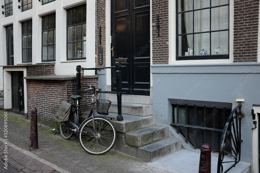 A bicycle parked at a house in one of Amsterdam's streets.