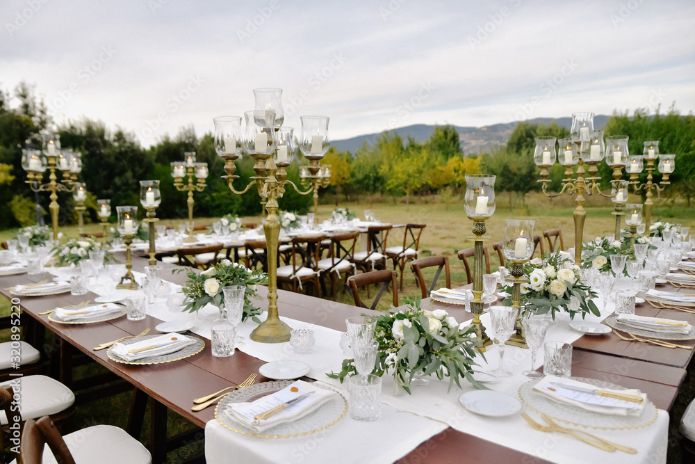 Decorated wedding celebration table with guests seats outdoors in the gardens with a mountain view