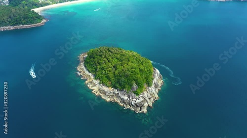 Nice rocks forested island, aerial panorama of Ko Pu against mountainous Phuket landscape on background. Deep tropical jungle thicket covering stony islend.Boat sailing. Aerial photo