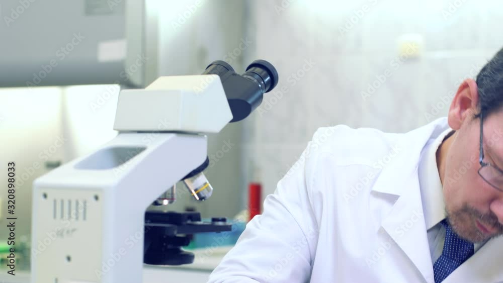 Chemist. A scientist conducts experiments in a scientific laboratory. Performs research using a microscope. Eureka. Victory. New discovery. Happy scientist. Chemist. A scientist conducts experiments in a scientific laboratory. Performs research using a microscope. Eureka. Victory. New discovery. Happy scientist.