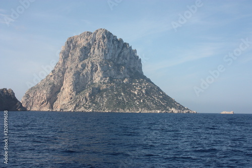 the islet of Es Vedra among the mist on the blue water of the ibiza sea © Alessia