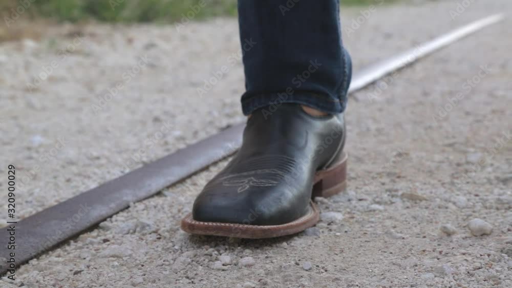 Cowboy fixing his pants above his cowboy boots. Cowboy fixing his pants above his cowboy boots.