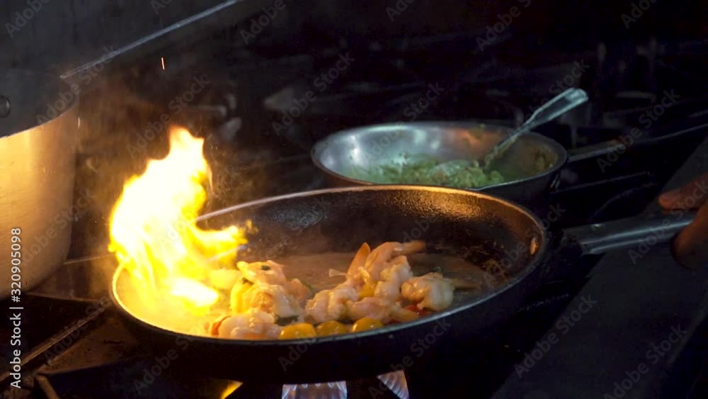 Fried shrimp in a pan that is on fire, Resturant kitchen Fried shrimp in a pan that is on fire, Resturant kitchen