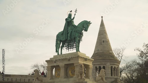 Statue of St. Stephen King Erected In The Center Of The City Between Fisherman's Bastion And Matthias Church In Budapest Hungary With Historical Architectural Designs Under Bright Sky - Wide Shot photo