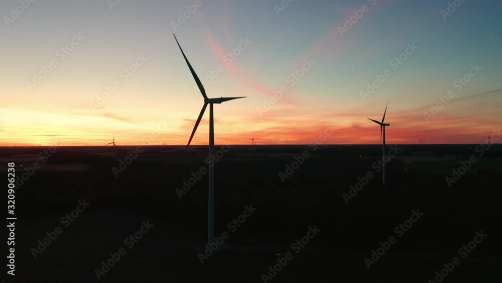 Aerial parallax of wind turbines silhouettes against a stunning sunrise Aerial parallax of wind turbines silhouettes against a stunning sunrise