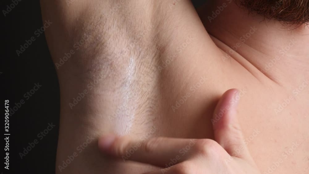 Man using Organic Deodorant Cream on his Shaved Armpits, Close-Up Man using Organic Deodorant Cream on his Shaved Armpits, Close-Up