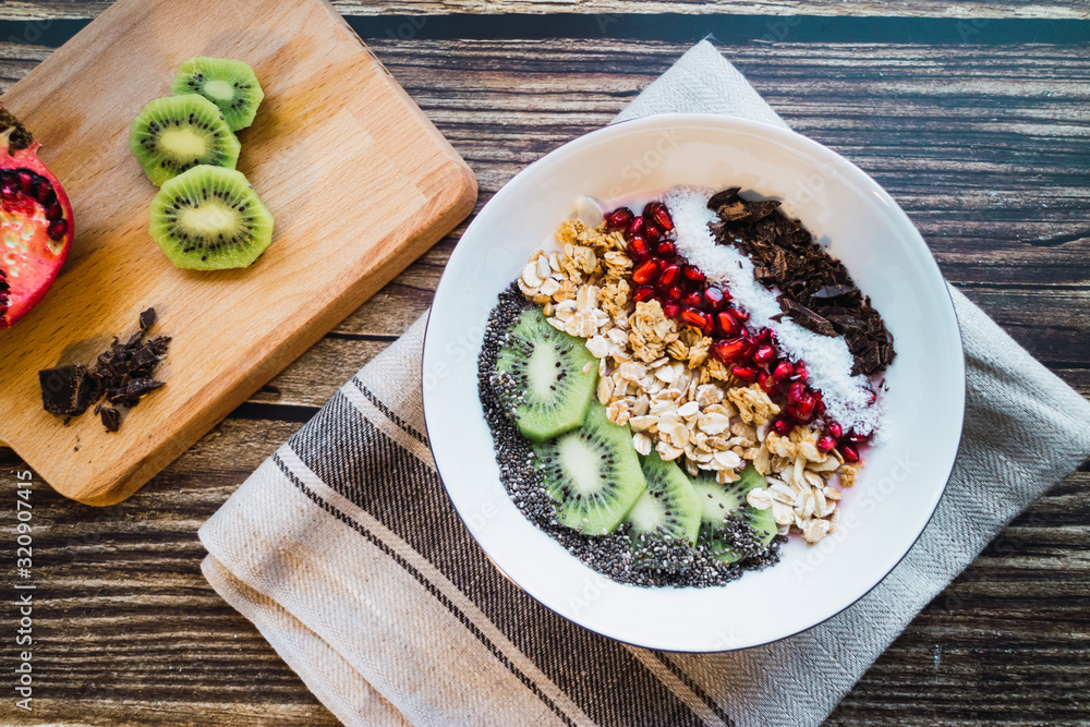 Vegan smoothie bowl with chocolate, coconut, pomegranate, grains, kiwi and chia. Top view. Vegan smoothie bowl with chocolate, coconut, pomegranate, grains, kiwi and chia. Top view.