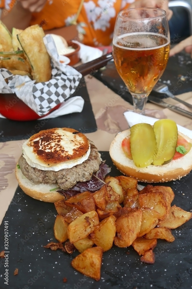 Burger with vegetables and eggs and fried potatoes in a restaurant. Selective focus.