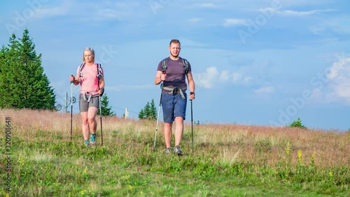 Two hikers reaching the top of a hill with healing energy points in Slovenia photo