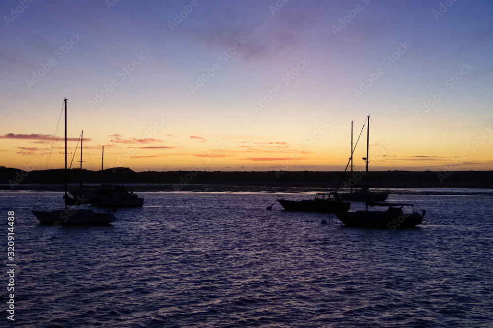 Panoramic view of a winter sunset on an ocean bay with moored boats