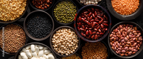 Legumes, a set consisting of different types of beans, lentils and peas on a black background, top view, close up. The concept of healthy and nutritious food