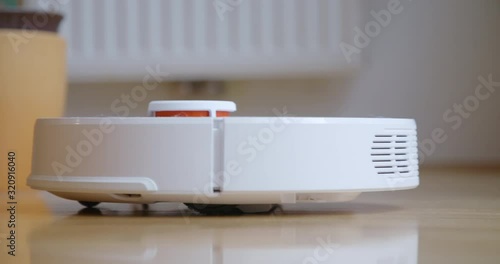 Robot cleaner cleans the room. Smart home. Robot vacuum cleaner performs automatic cleaning of the apartment at a certain time. 