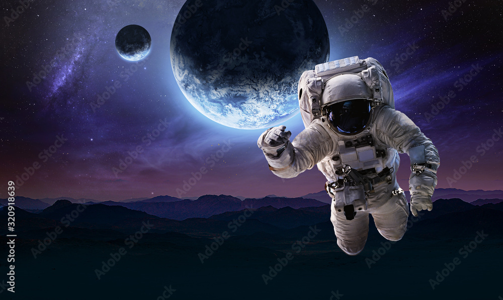 Astronaut in the space over the nightly planet Earth. Abstract wallpaper.  Spaceman. Elements of this image furnished by NASA Stock Photo