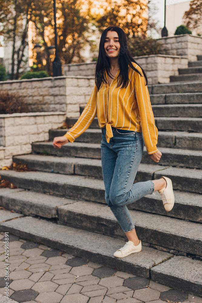 Young pretty woman on city stairs sit and jump Young pretty woman on city stairs sit and jump