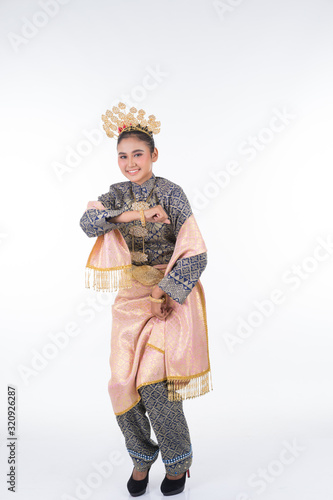An attractive Malaysian traditional female dancer performing a cultural dance routine called Tarian Zapin in a traditional dance outfit. Full length isolated in white. © HEMINXYLAN