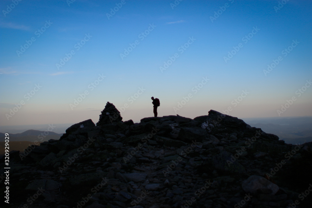 Backpacker Silhouette Against a Blue Faded Skyline Backpacker Silhouette Against a Blue Faded Skyline