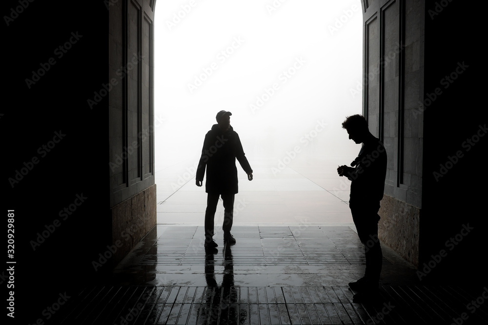 A two man stands in a fog near a monastery in the province of Catalonia, Spain.