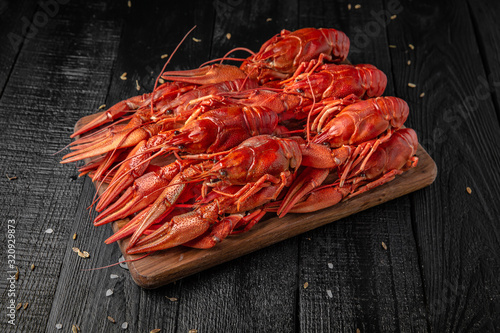 Fresh hot red crawfish with lemon on dark wood table. Beer snack. Octoberfest party dinner. Festive table with delicious food. 