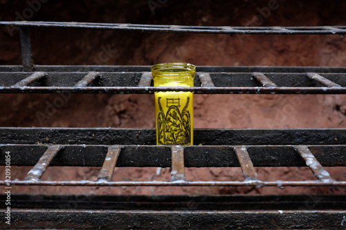 Montserrat, Spain - April 26: Detail of a yellow candle in a holder in a monastery in the province of Catalonia on April 26, 2017 in Montserrat, Spain.