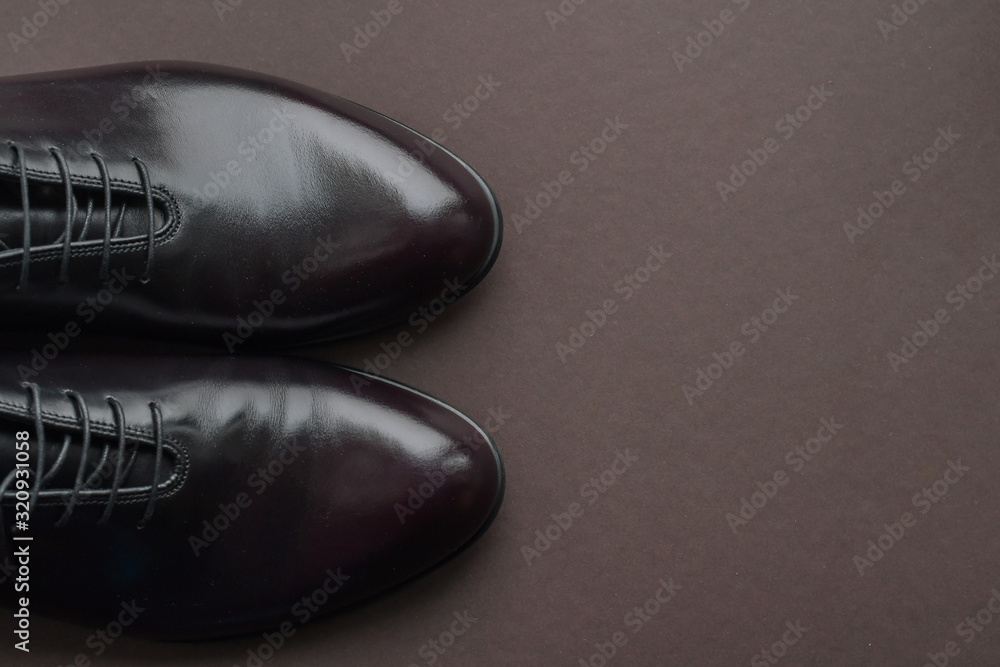 Close of fashionble men dark red leather shoes on dark background. 