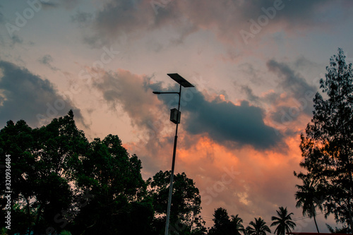 Abstract wallpapers of a blurry nature of colorful sky by the lake, with coconut palms and green fields, with cows walking on grass, seen in rural areas