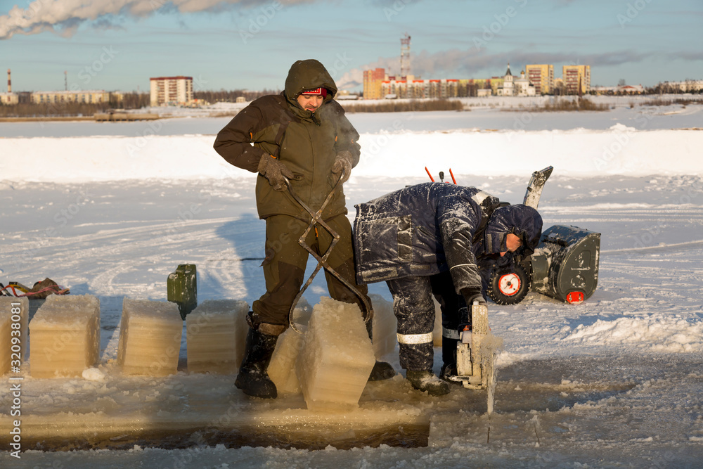Naklejka premium Worker cuts the ice with a gasoline saw