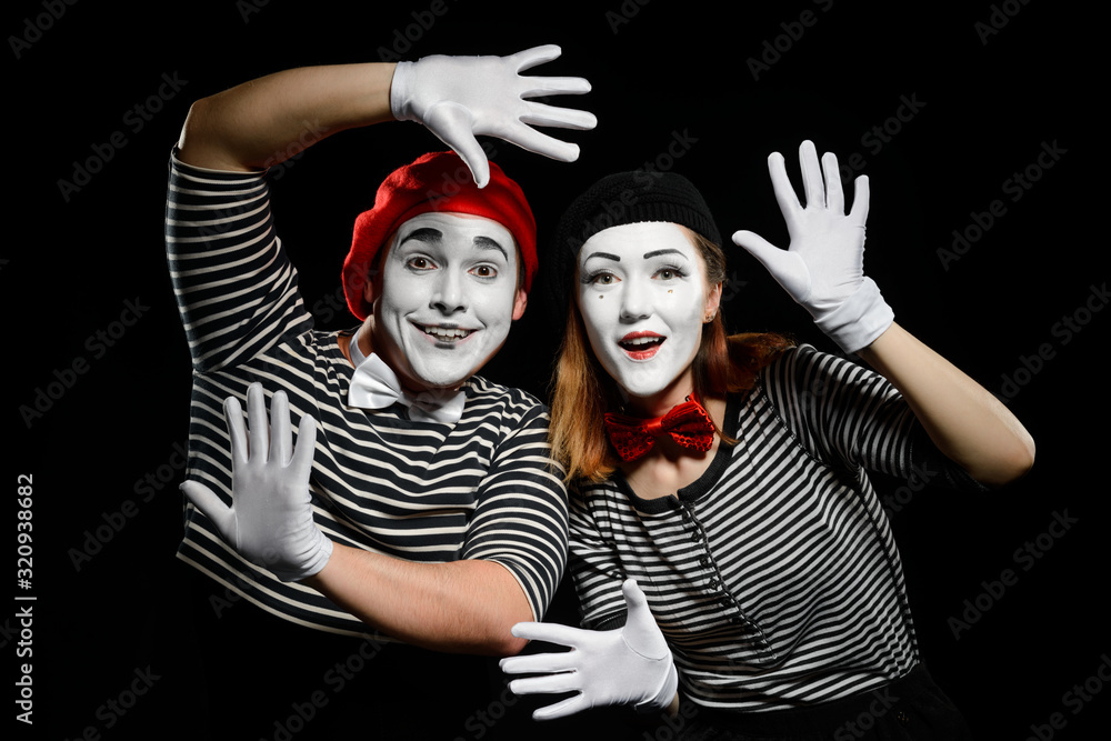 Smiling mimes in striped shirts. Man and woman, dressed as actors Smiling mimes in striped shirts. Man and woman, dressed as actors