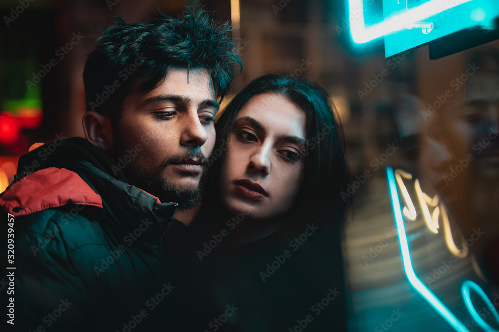 Happy couple hugging each other under street lights. Happy couple hugging each other under street lights.