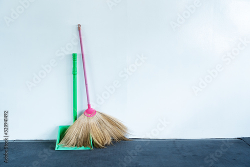 Bloom and dustpan put together on the white wall