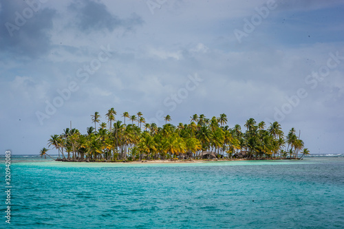 Palm fringed island in turquoise blue ocean