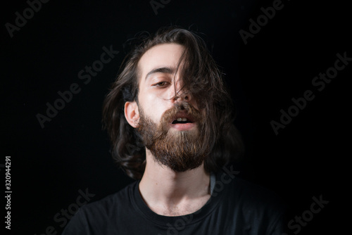 Hipster teenager hair tossing, black isolated background. Freedom concept.
