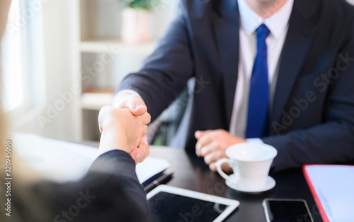 Businessman making handshake in office room - business etiquette, congratulation, merger and acquisition concepts