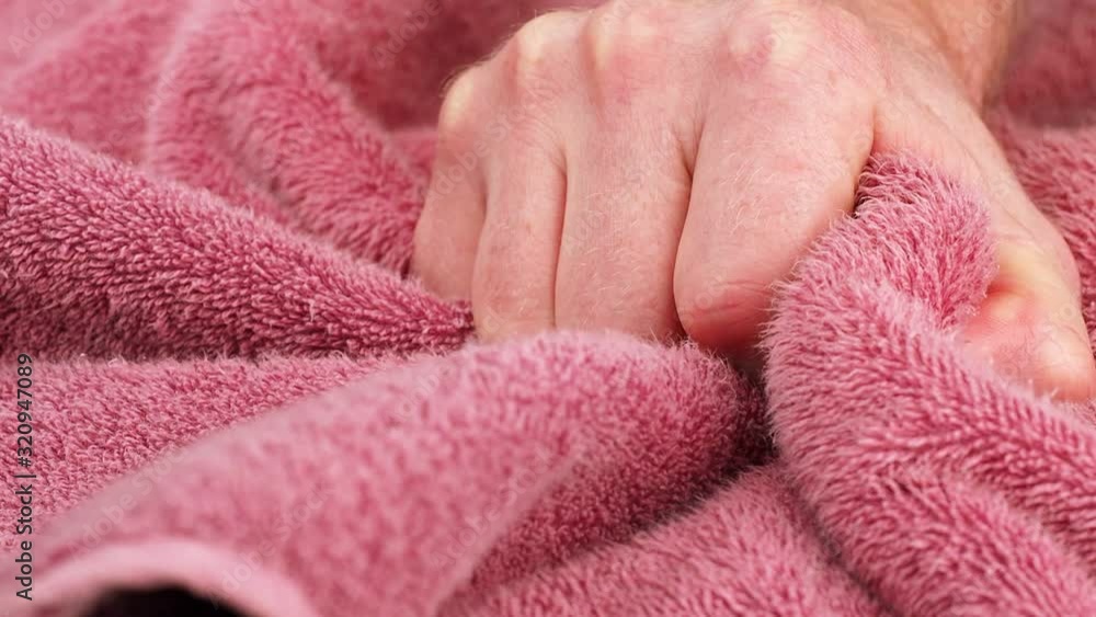 Man hand squeezing of Pink Terry towel, macro shot. Fabric of towel, close up. Hand is forcefully clenched into a fist and remains in the frame. Static camera. Close-up view, full HD Man hand squeezing of Pink Terry towel, macro shot. Fabric of towel, close up. Hand is forcefully clenched into a fist and remains in the frame. Static camera. Close-up view, full HD