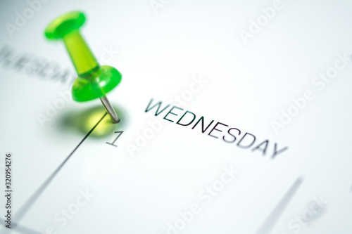 Green push pin on the 1st  date of the calendar Wednesday - 1st of April Wednesday - April fools day 2020