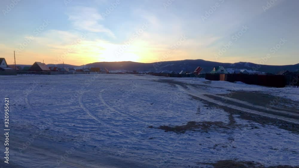 Sunset Over Snowy Field In Mongolian Village Of Khatgal