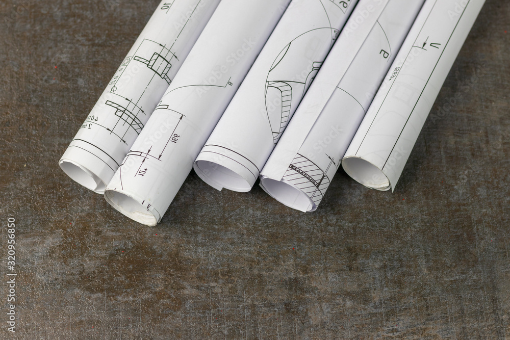 Wooden background. On it are blueprints or a plan of the future home or knowledge. They are rolled up. Wooden background. On it are blueprints or a plan of the future home or knowledge. They are rolled up.