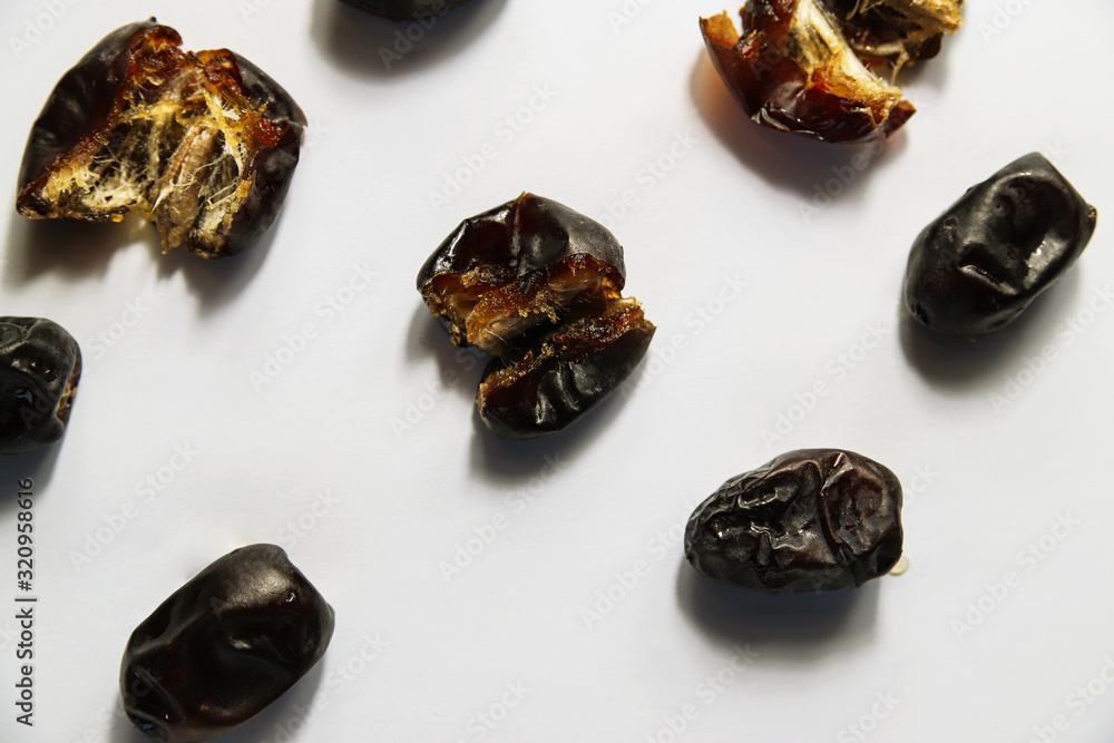Open dried dates fruits on white background. Minimal healthy sweet food, studio shooting, flat lay, top view Open dried dates fruits on white background. Minimal healthy sweet food, studio shooting, flat lay, top view