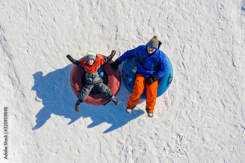 Father and son snow tubing in the winter in Canada photo
