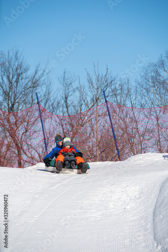Obraz na płótnie Father and son snow tubing in the winter in Canada w salonie