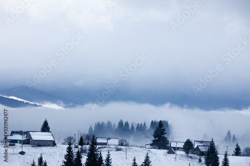 rural scene snowed village in mountains misty fogy morning