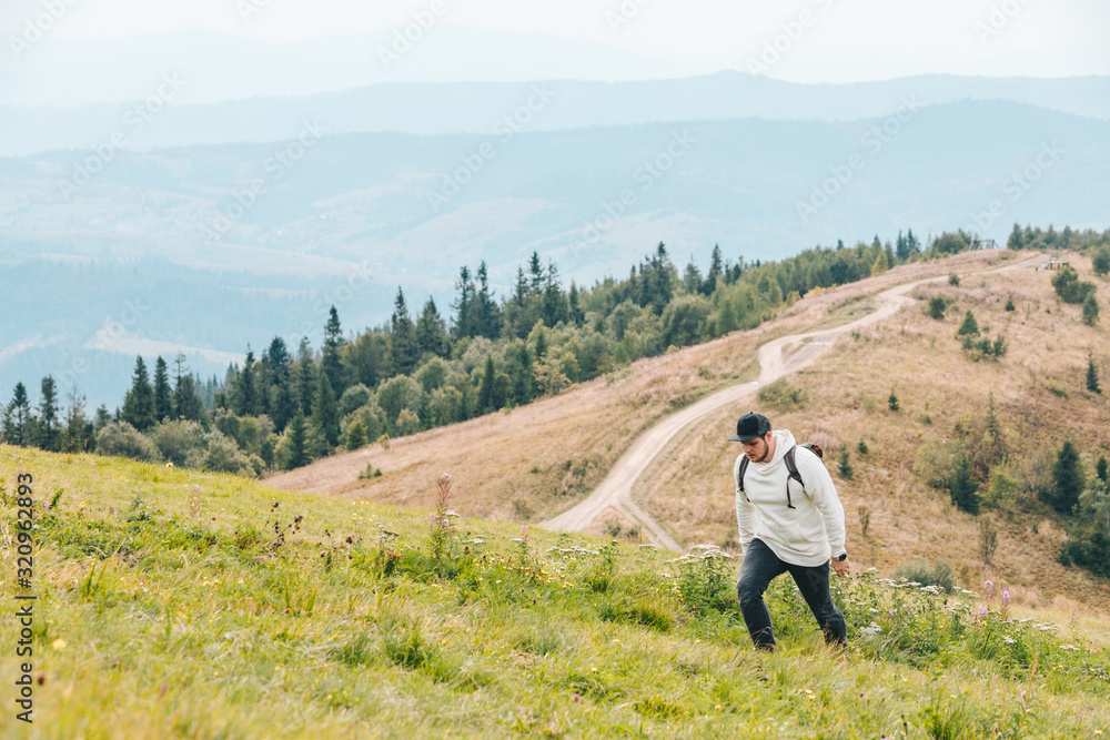 man with backpack hiking in mountains