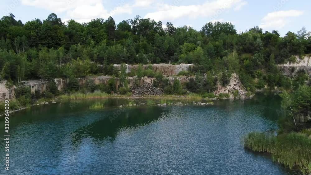 Aerial View of lake with a Small Island and Beautiful Water in a Quarry Surrounded by Forest Tracking Forward Aerial View of lake with a Small Island and Beautiful Water in a Quarry Surrounded by Forest Tracking Forward