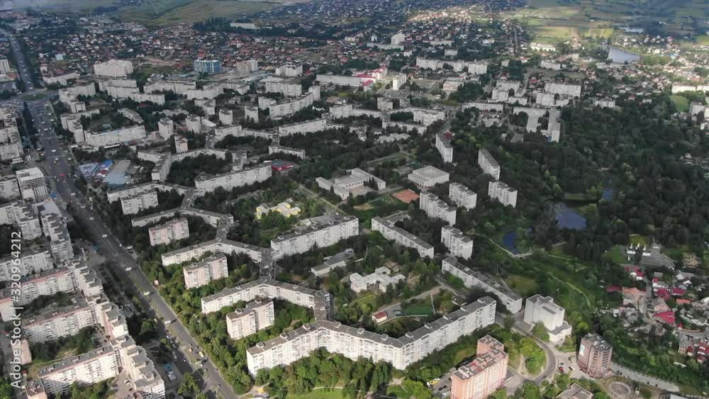 Aerial View of Geometrically Shaped Buildings in a City Surrounded by Trees Near Busy Road Aerial View of Geometrically Shaped Buildings in a City Surrounded by Trees Near Busy Road