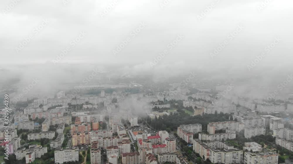 Aerial View Through Clouds Revealing Cityscape on a Foggy Day Pan Down Aerial View Through Clouds Revealing Cityscape on a Foggy Day Pan Down